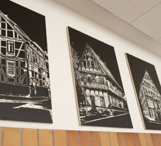Foto einer Wand mit drei Schwarz-Weiß-Bildern von Fachwerkhäusern