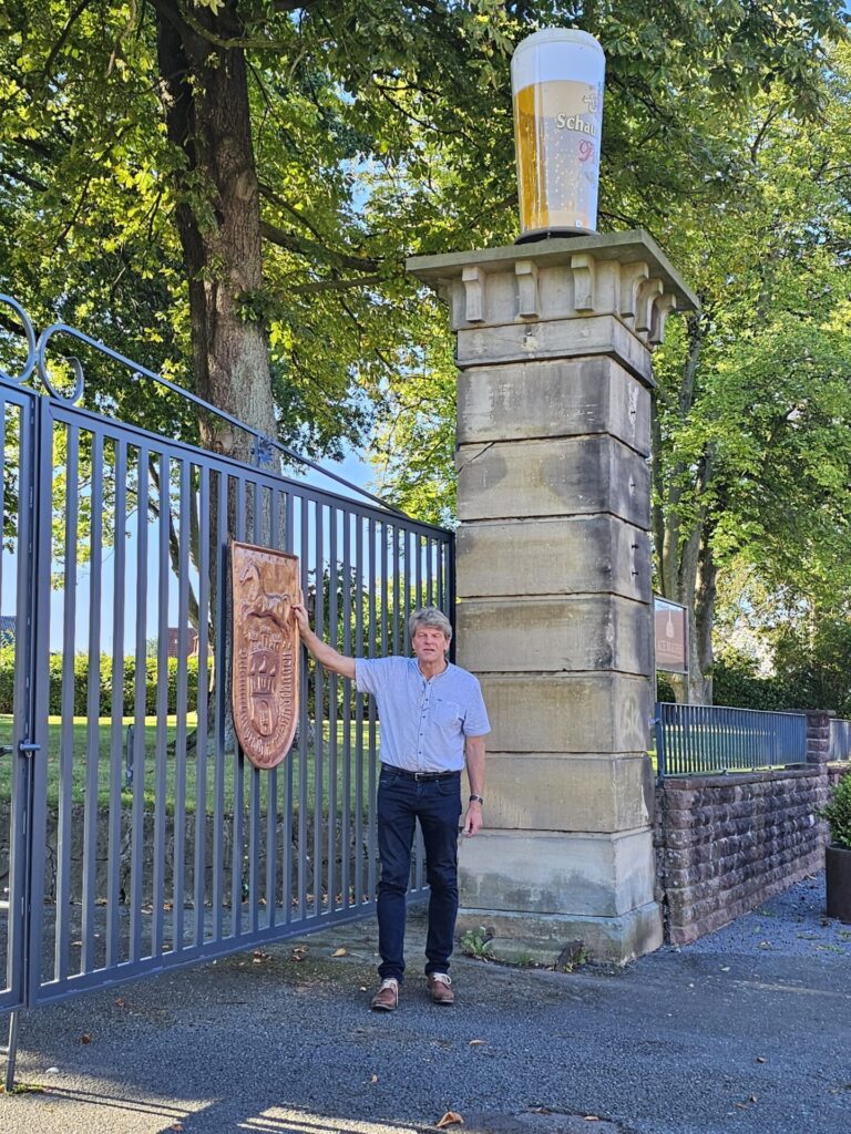 Herr Friedrich-Wilhelm Lambrecht präsentiert die Bronze-Plakette an dem Eingangstor des Gewerbeparks "Alte Brauerei".